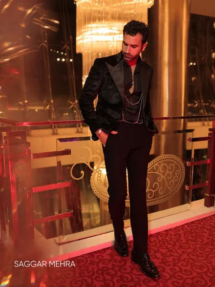 Another shot of the black velvet coat, this time showing the full silhouette with the added detail of a waistcoat chain. It’s a modern take on classic evening glamour.