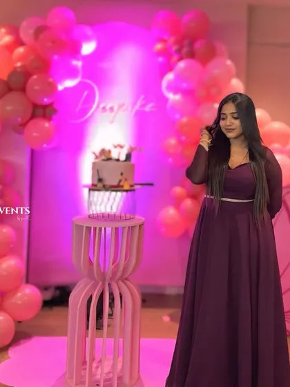 The birthday girl enjoying her pretty-in-pink butterfly-themed party. The shades of pink balloons and custom name sign create a perfect photo backdrop.