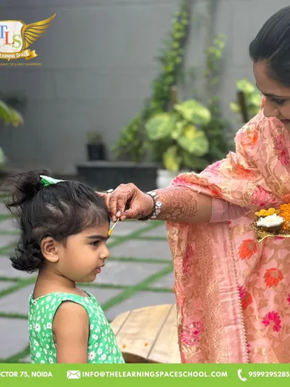 A teacher applies a tilak to a child's forehead. This simple, warm gesture is a beautiful part of our festive welcoming ceremony, making every child feel included.