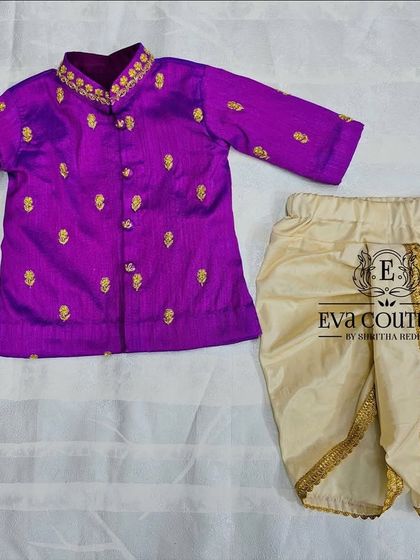 A twinning set for a brother and sister. The newborn girl's Pattu Pavadai is perfectly coordinated with her brother's purple kurta and dhoti.