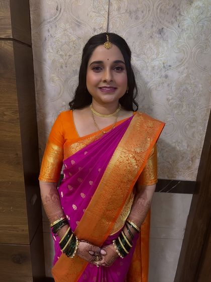 The full look for this engagement ceremony, featuring a bright pink and orange saree. I provided makeup, hairstyling with soft curls, and expert saree draping.