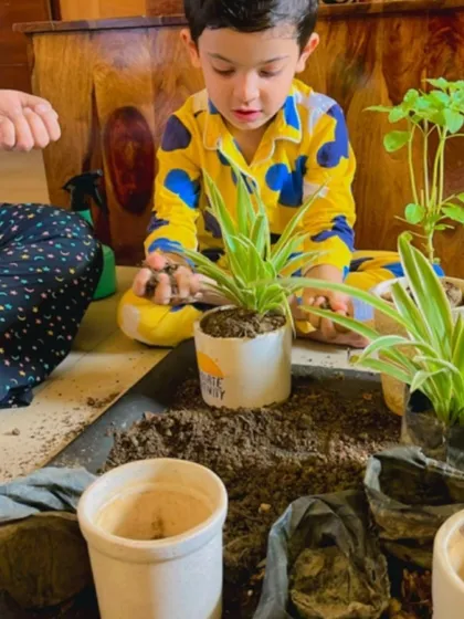 A young student carefully plants a sapling, learning the importance of nurturing nature from an early age.