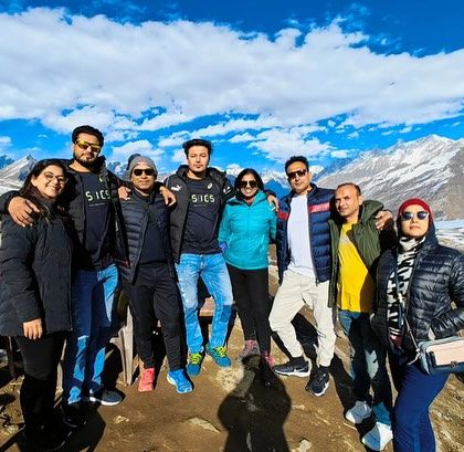 A happy group moment against the stunning backdrop of the snow-capped Himalayas in Manali.