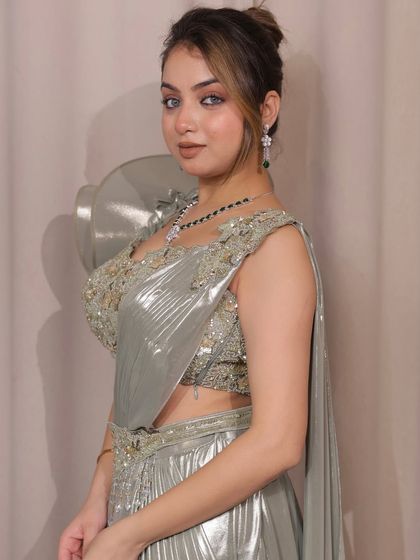 A close-up of our sage green pre-draped saree. The metallic fabric and hand-embroidered blouse make it a luxurious choice for any grand celebration.