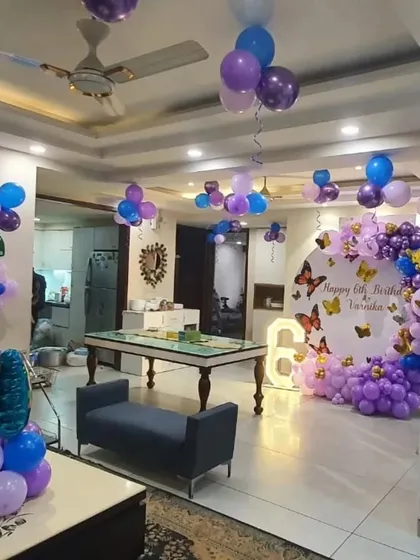 A full view of a home decorated for a butterfly-themed birthday, showing the main backdrop and ceiling balloons.