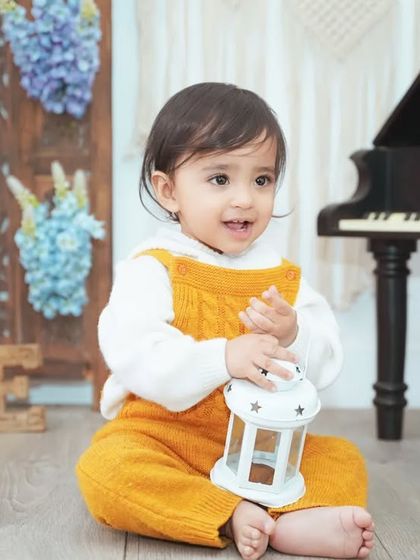 A sweet portrait of a baby boy holding a lantern prop during his first birthday session.