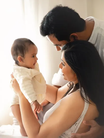 A family bathed in beautiful window light. This classic, airy style of photography creates timeless portraits that feel both intimate and artistic.