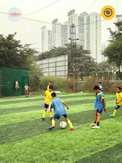 A young player skillfully maneuvers the ball, looking for a pass during a Strikers Showdown match.