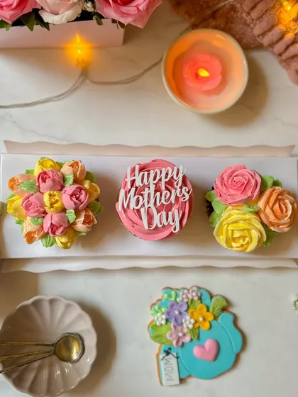 A trio of my Mother's Day floral cupcakes, showcasing different hand-piped flower designs from roses to tulips. Each one is a testament to the delicate artistry I bring to my baking.