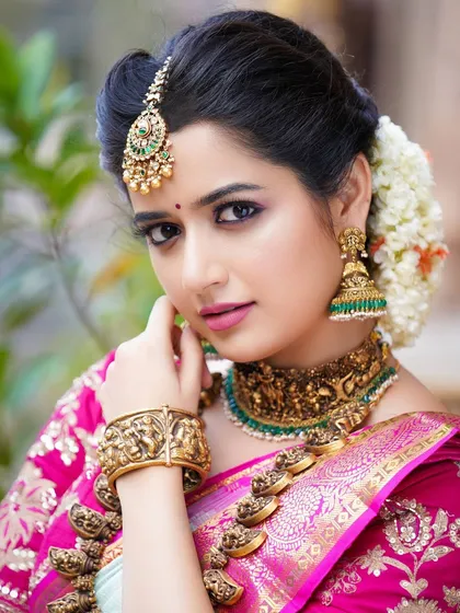 Another beautiful portrait of Ashika Ranganath, showcasing the fine details of her makeup and the traditional floral hair arrangement.