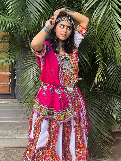 A playful pose in a gorgeous outfit. This chaniya choli is perfect for anyone who loves traditional designs with a pop of color.