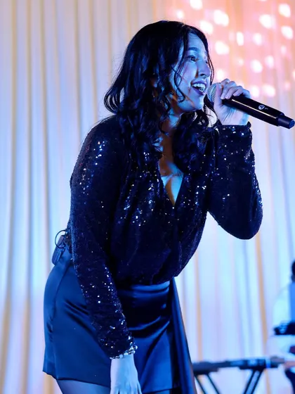 Singing under the blue lights at a private party. We work with event planners to ensure our stage setup and lighting complement the event's ambiance.