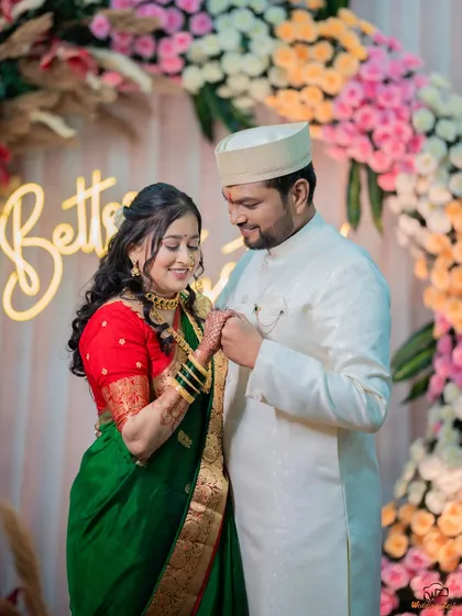 Prachi and Ketan during their ring ceremony, set against a beautiful floral arch with a "Better Together" sign. This shot captures the central moment of the engagement.