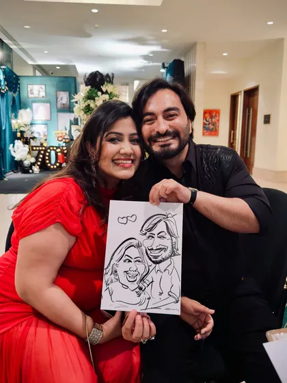 A happy couple at a party, holding their caricature. My sketches are designed to steal the show and hearts at any celebration.