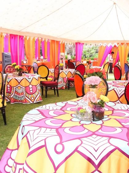 The decor is in the details. We used custom-printed tablecloths with vibrant patterns and multi-colored chairs to bring the "Rangeela Rajasthan" theme to life in the guest dining area.