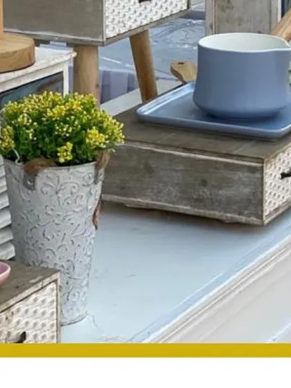 A charming and rustic decor setup for an outdoor wedding, featuring pastel-colored pots, small lamps, and wooden crates for a whimsical, cozy feel.