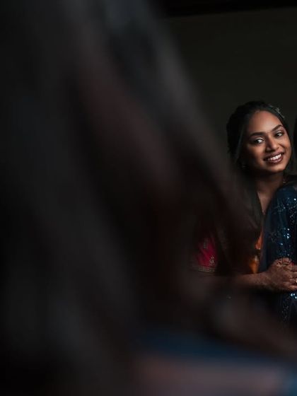 A creative mirror shot of Dr. Akshara and her sister. This photo captures a sweet, intimate moment between them during the reception.