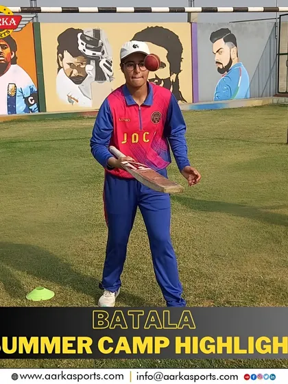 A student practices his batting technique during the summer camp, with murals of sports icons watching over him.