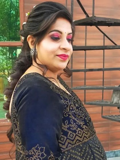 A side profile of a client after her makeover. The makeup features a bold pink eye and lip, paired with a soft braided hairstyle.