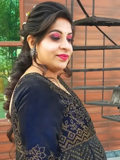 A side profile of a client after her makeover. The makeup features a bold pink eye and lip, paired with a soft braided hairstyle.