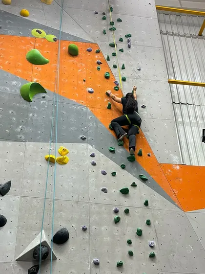 A climber scales one of the tall routes during our anniversary competition, showcasing her strength and endurance.