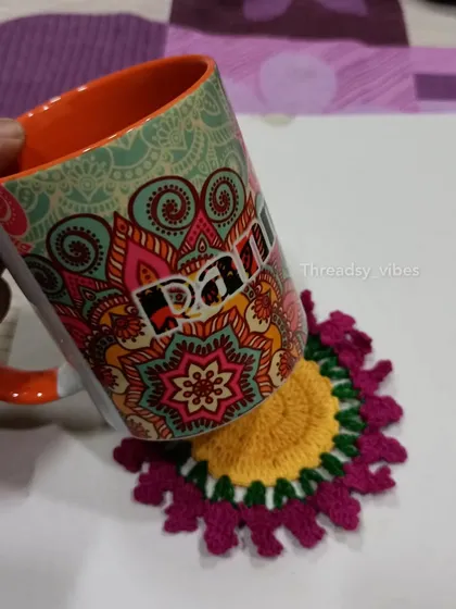 Here is one of my floral coasters in action, holding a colorful mug. The yellow and magenta design adds a cheerful touch.