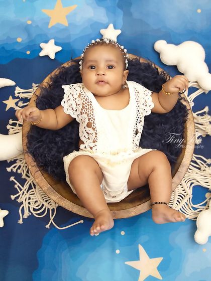 Another angle from the celestial sitter session, showing the full setup with a crescent moon and soft cloud props.