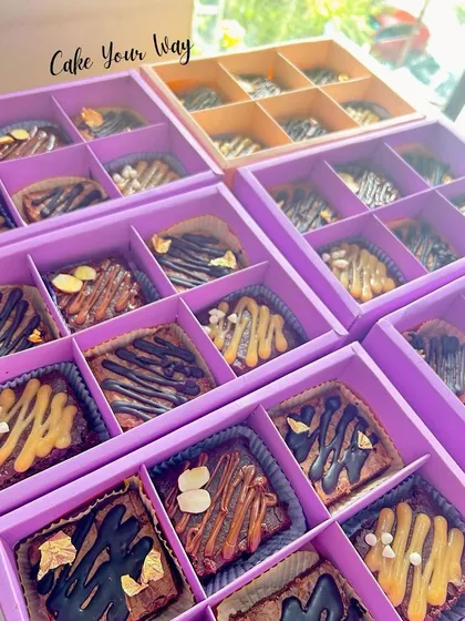Boxes of my assorted fudgy brownies, ready to be packed as return favors. Each brownie is drizzled with chocolate and topped with nuts for extra flavor and crunch.