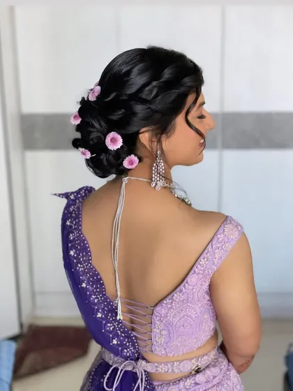 A side view of this pretty floral bun. The loose tendrils framing her face add to the soft, romantic feel of the hairstyle.