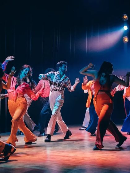 A wide shot of the stage, capturing the incredible energy of the audience and the performers after a fantastic show.