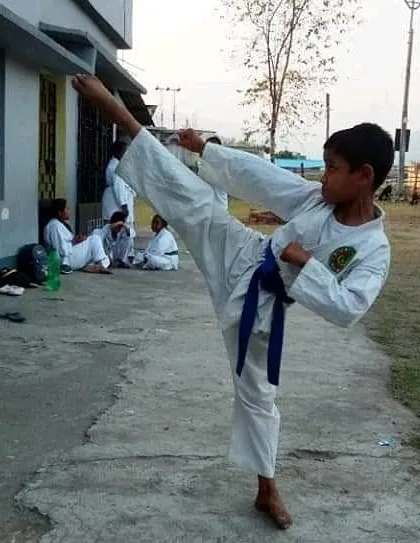 A young blue belt student practices his side kick. Each belt represents a new level of understanding and skill, and we guide our students through every stage of their karate journey.