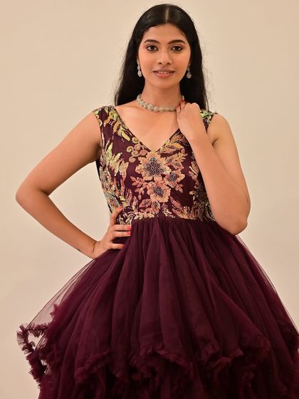 A model in a beautiful embroidered purple gown.