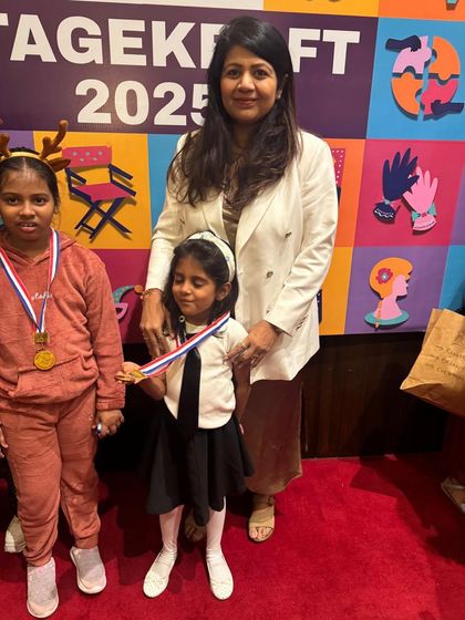 A teacher with her students, celebrating their wonderful performances and the joy of being on stage.