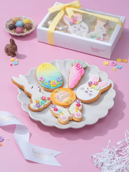 A box of my decorated Easter cookies, showcasing the variety of shapes and pastel colors that define this collection.