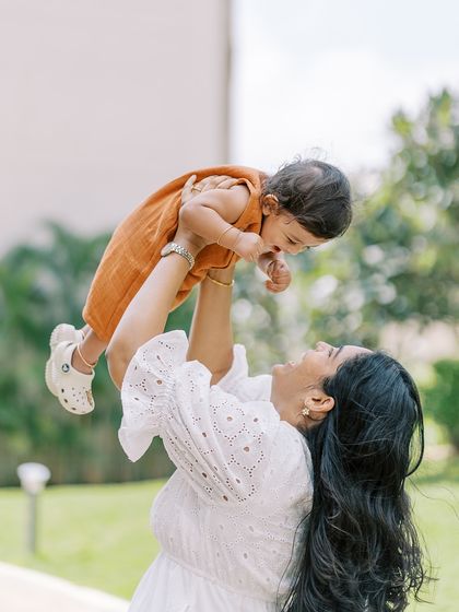 A mother lifting her laughing baby into the air. A classic "flying baby" shot that is always full of joy.