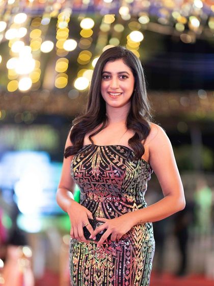 A candid, smiling shot from the red carpet, capturing a moment of genuine happiness amidst the glamour of the event.