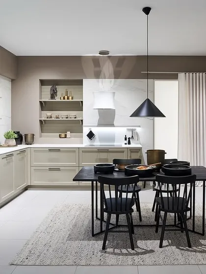 This kitchen combines classic shaker-style cabinets in a soft beige with a modern black dining set, showing how we can blend traditional and contemporary elements.