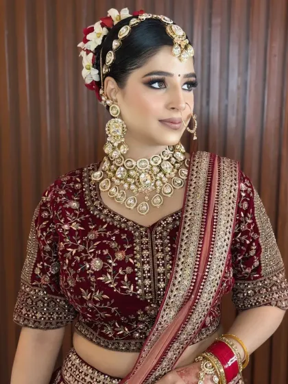This bride's look is all about classic elegance, with a beautiful floral bun, kundan jewelry, and a soft, nude-toned lip.