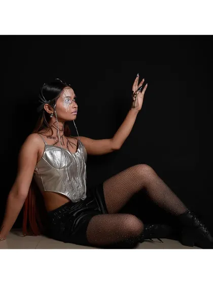 A wider angle of the futuristic look, showing how the makeup, styling, and pose work together to tell a story. The silver and black palette creates a sleek, sci-fi inspired character perfect for a conceptual fashion shoot.