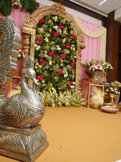 A detailed shot focusing on the silver peacock prop, a symbol of grace and beauty, placed strategically to enhance the traditional theme of the celebration.