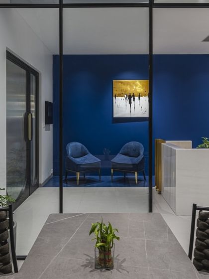 A view from the meeting room into the reception area of a modern Mumbai office. The use of glass walls maintains an open feel while delineating separate functional zones, blending privacy with a collaborative spirit.