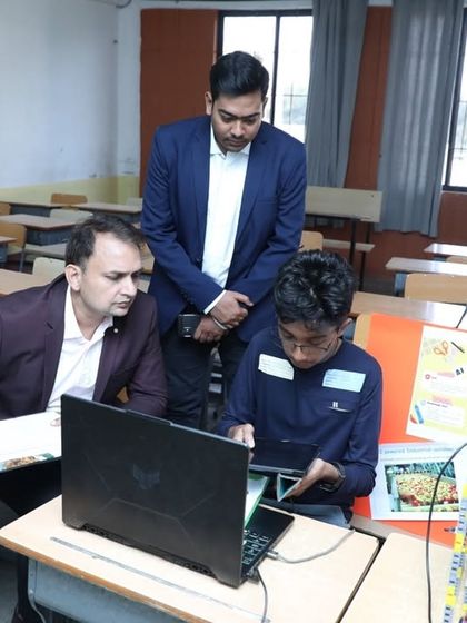 Our founder and a judge review a student's app development project at RW2024. We encourage students to tackle ambitious projects that combine coding, creativity, and real-world problem-solving.