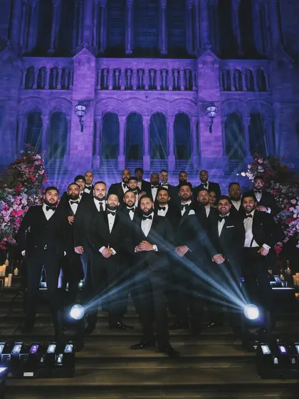 The groom and his groomsmen posing on the grand staircase. The lighting design by Kudos AV perfectly highlighted the stunning architecture of the Natural History Museum.