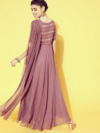 The back view of the mauve saree-dress, highlighting the flowing attached pallu and the sequin work on the bodice. The lightweight georgette fabric ensures comfort and graceful movement.