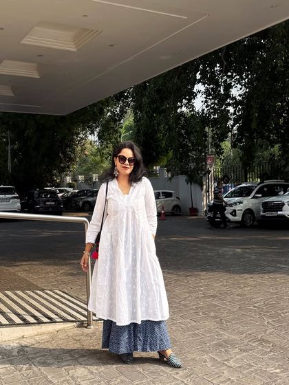 A full-length view of the white kurta ensemble, showcasing its flow and elegance in an outdoor setting. Your style should empower you, whether you are indoors or on the move.