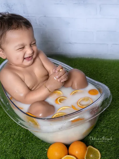 An infectious giggle captured during a citrus-themed milk bath session. These shoots are a wonderful and unique way to photograph babies.
