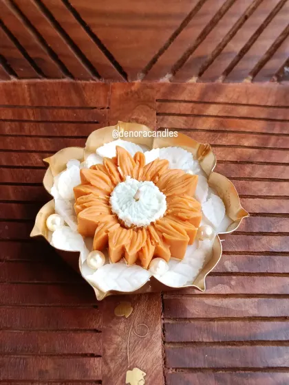 A single sunflower-style urli candle, featuring a large orange flower as the centerpiece.