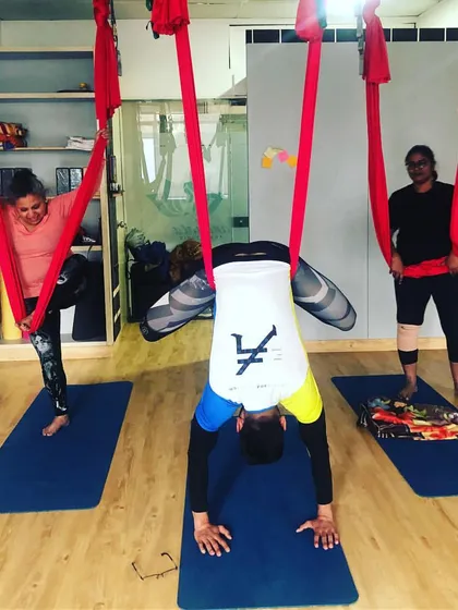 Each person's journey is unique. Here, students explore different levels of an inversion during the same class, honoring their individual practice and potential.