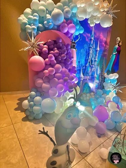 This angle highlights the depth of the decoration, with Olaf the snowman in the foreground and the detailed balloon arch framing the entire magical scene.