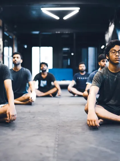A group of fighters meditates together, a practice that builds mental fortitude.